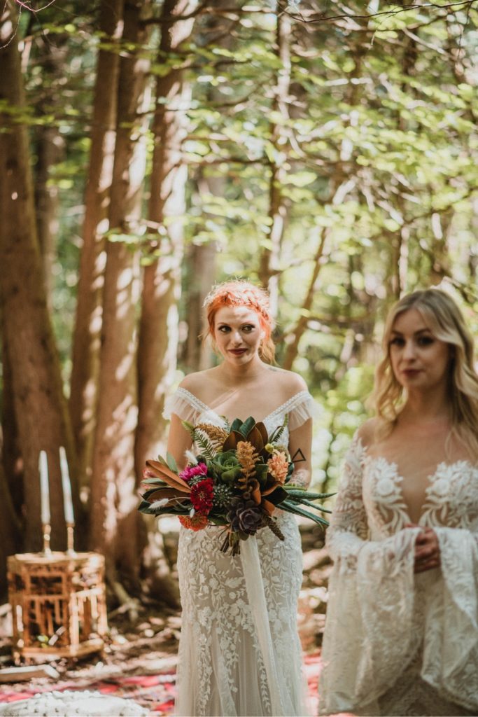two brides in wedding dresses in forest