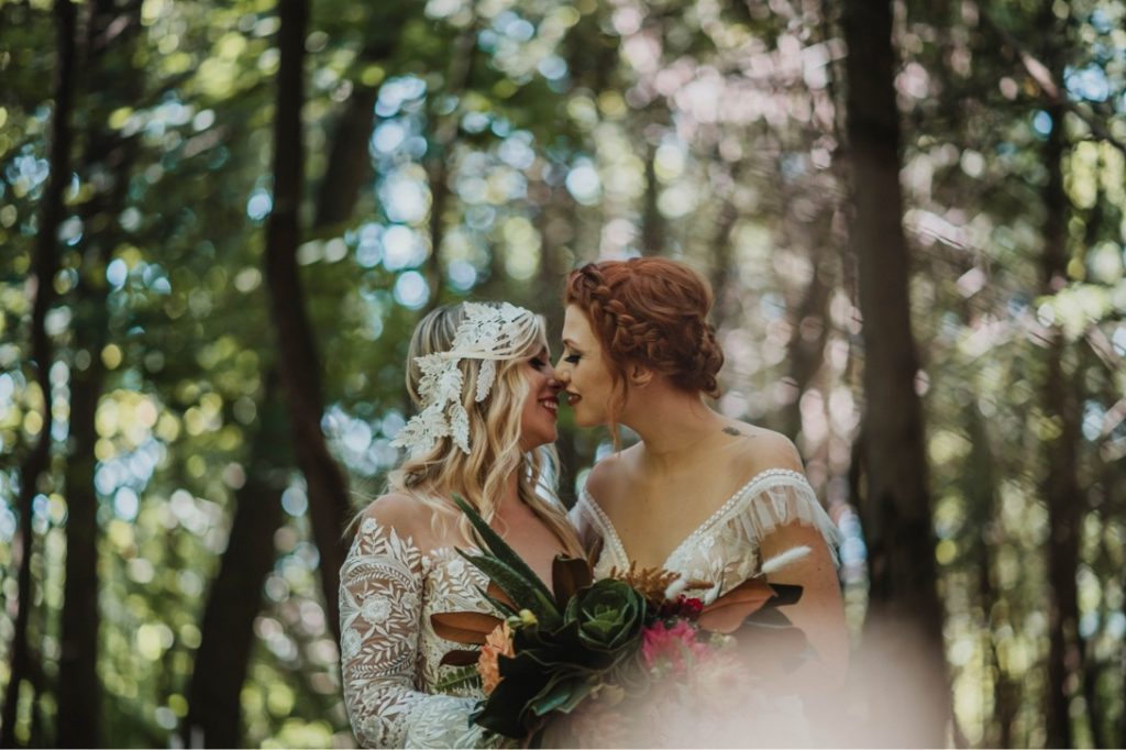 lesbian couple kissing in outdoor wedding ceremony