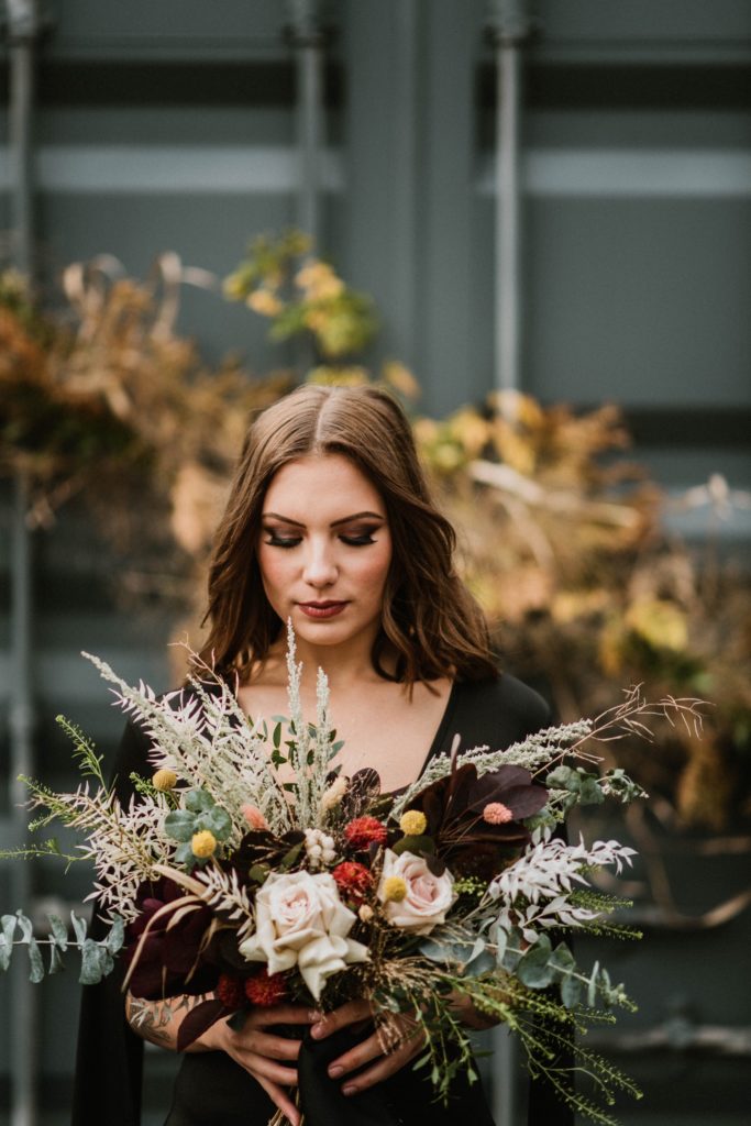 offbeat bride holding fall wedding bouquet