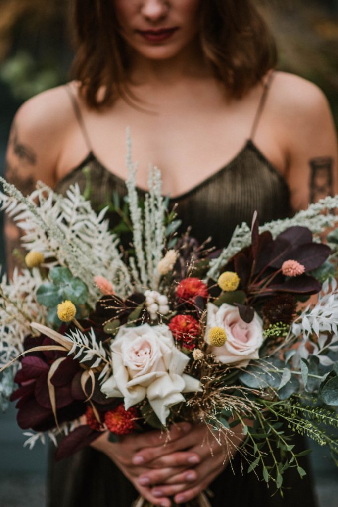 offbeat bride in gold gown holding fall wedding bouquet