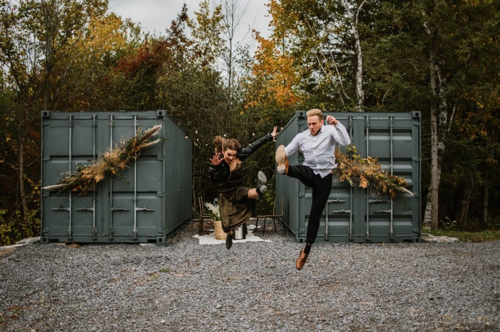 offbeat bride and groom doing high kicks at outdoor elopement