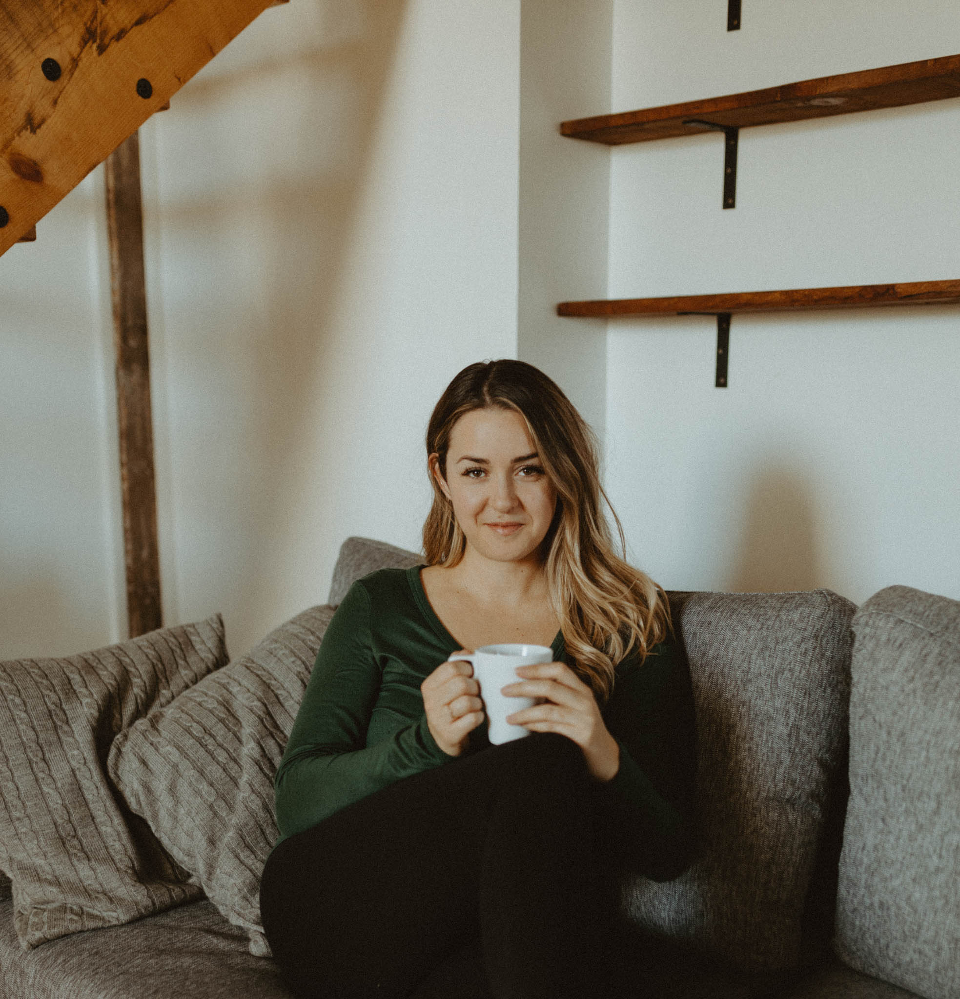 girl sitting on couch holding a cup of coffee