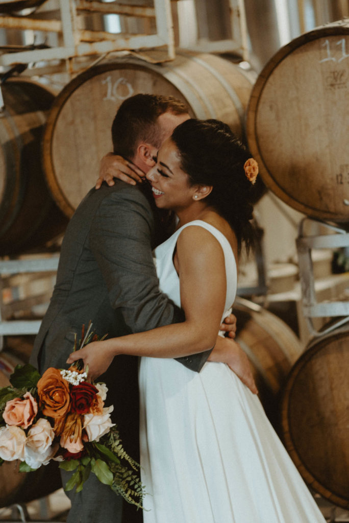 bride and groom hugging at intimate brewery elopement