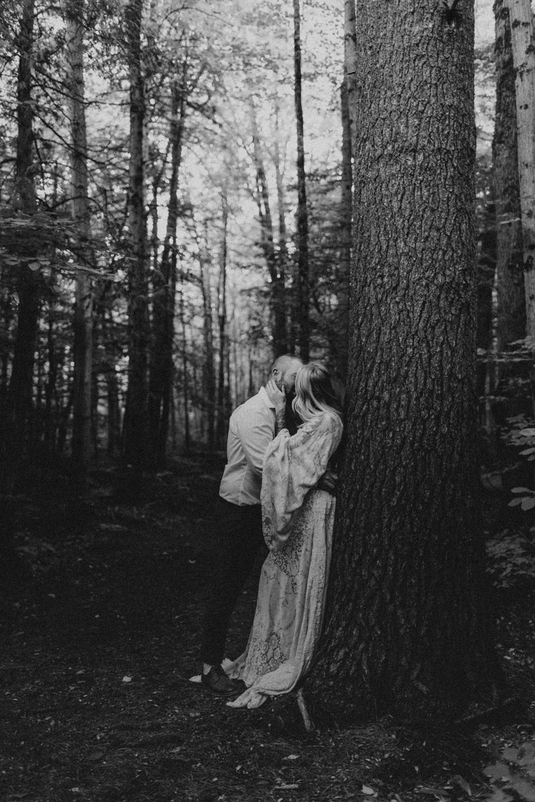 bride and groom kissing in forest
