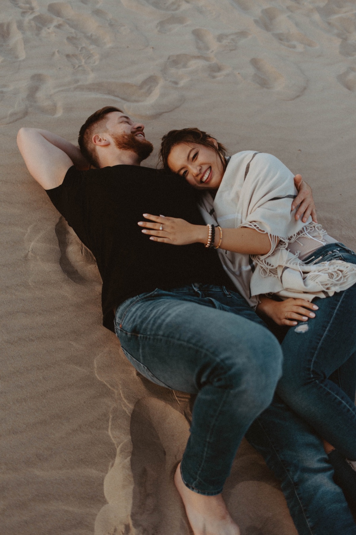 couple lying in the sand at Sandbanks Provincial Park
