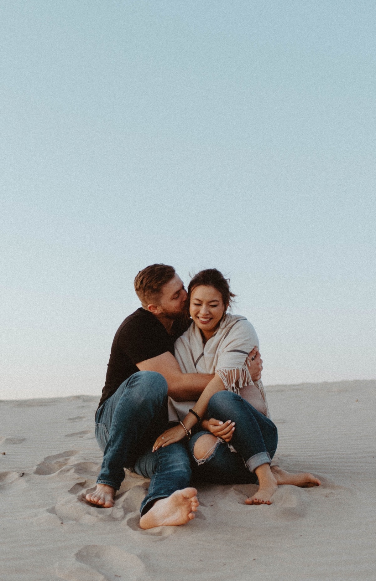 Couple sitting in sand dunes