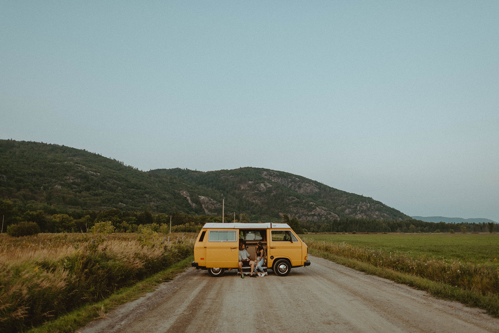 vintage yellow VW van on dirt road