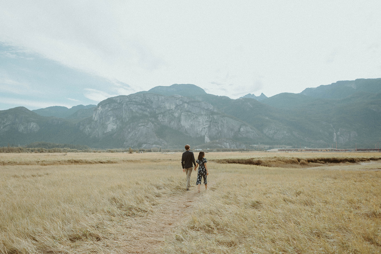 couple walking toward mountain range