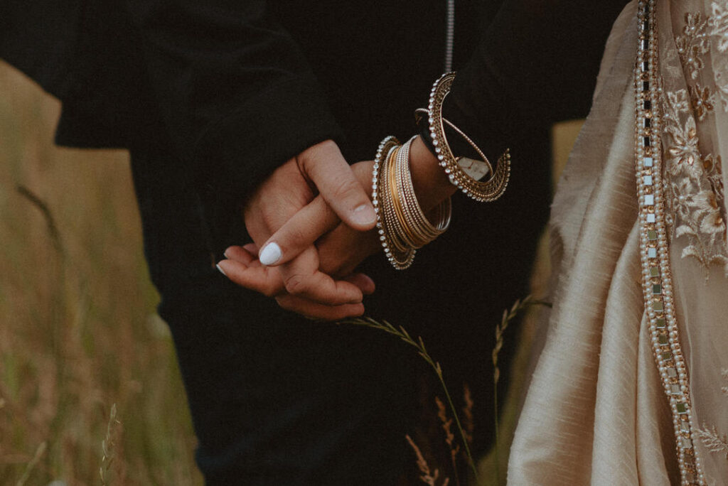 Indian couple holding hands in wedding attire