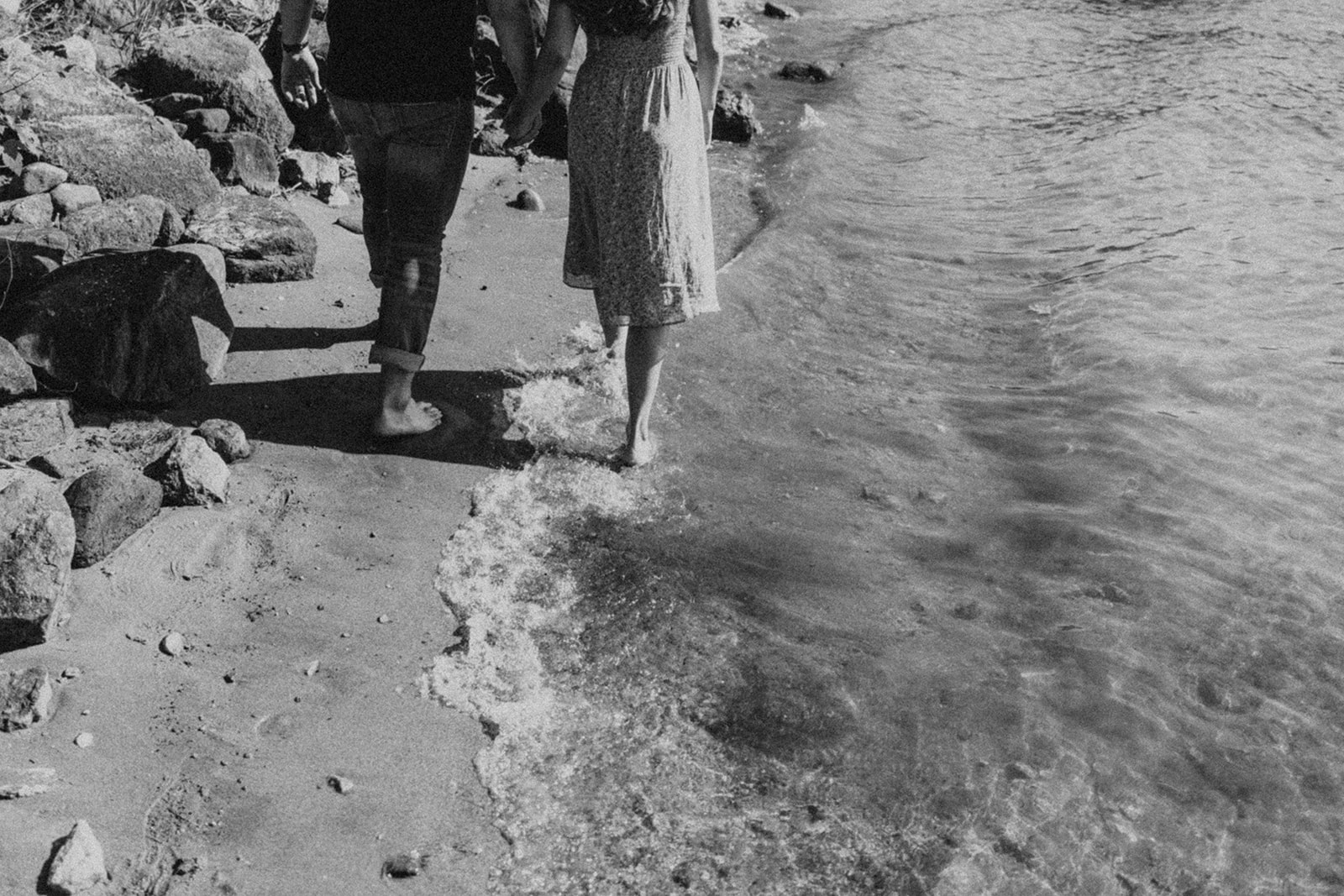 couple walking along rocky shore