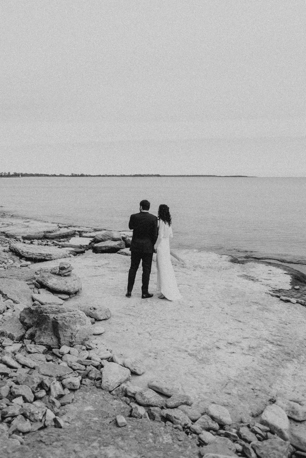 bride and groom walking along coast