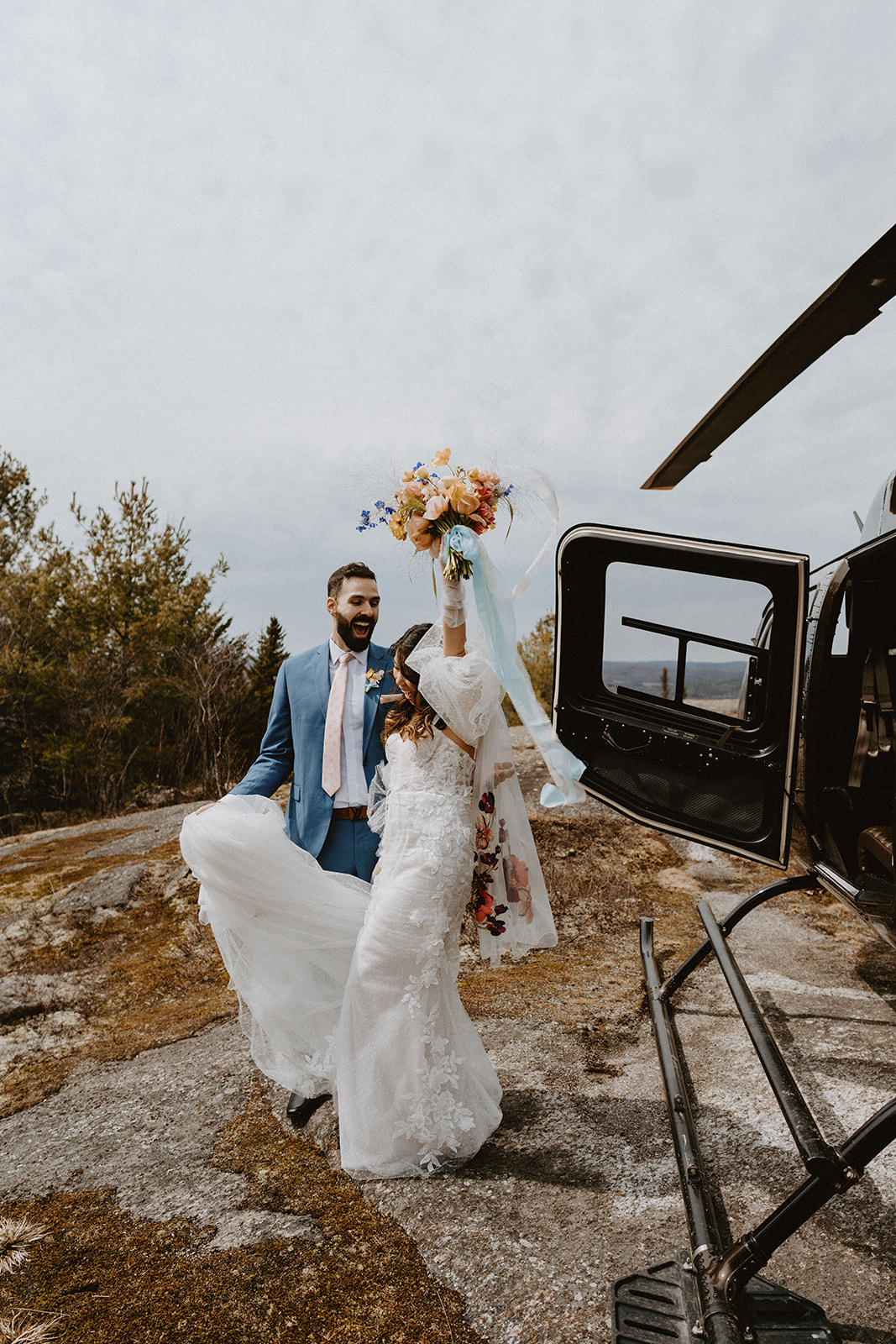 bride and groom stepping out of helicopter