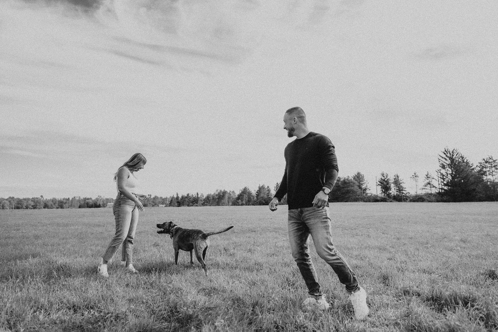 couple with dog in field