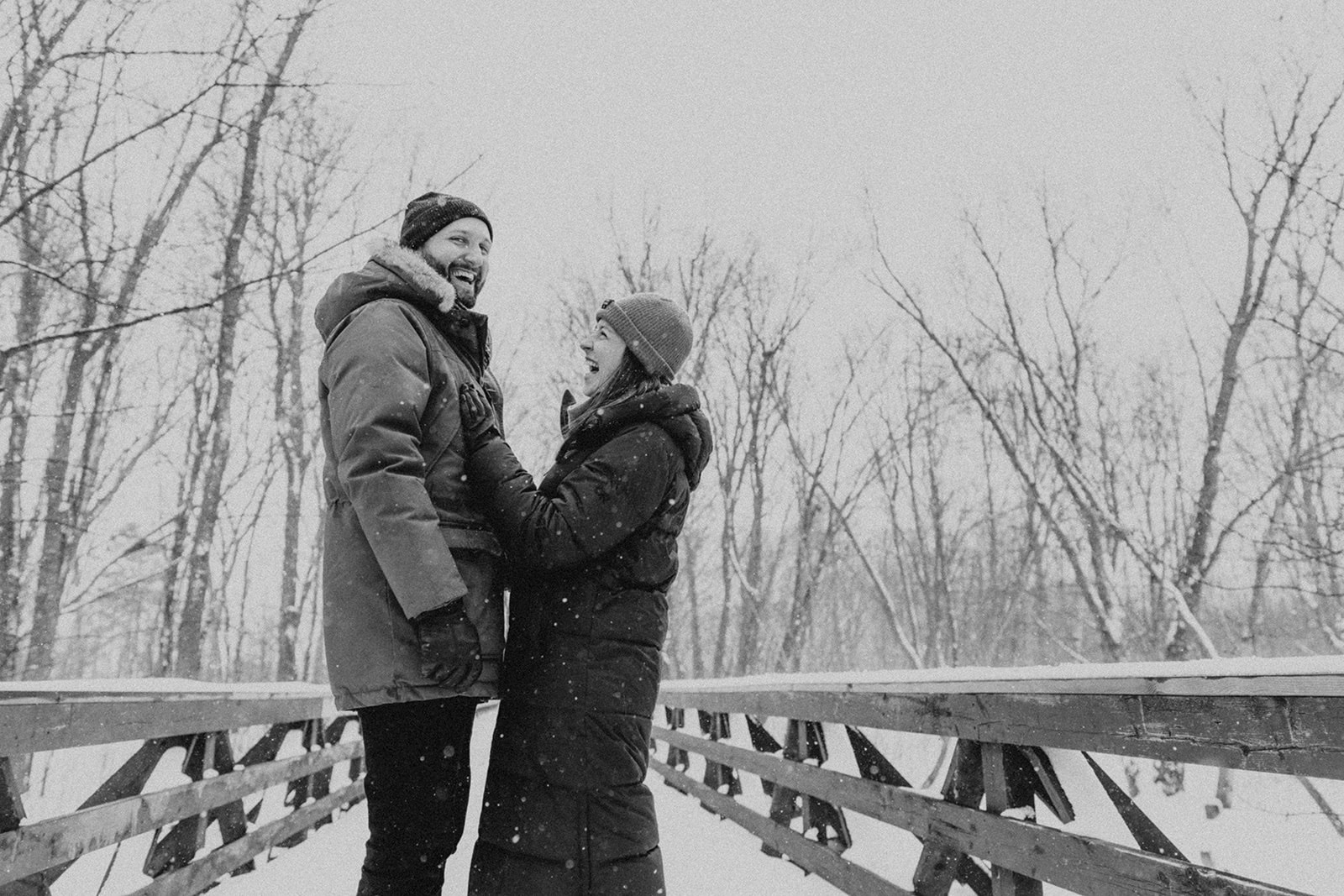 couple standing on snowy bridge