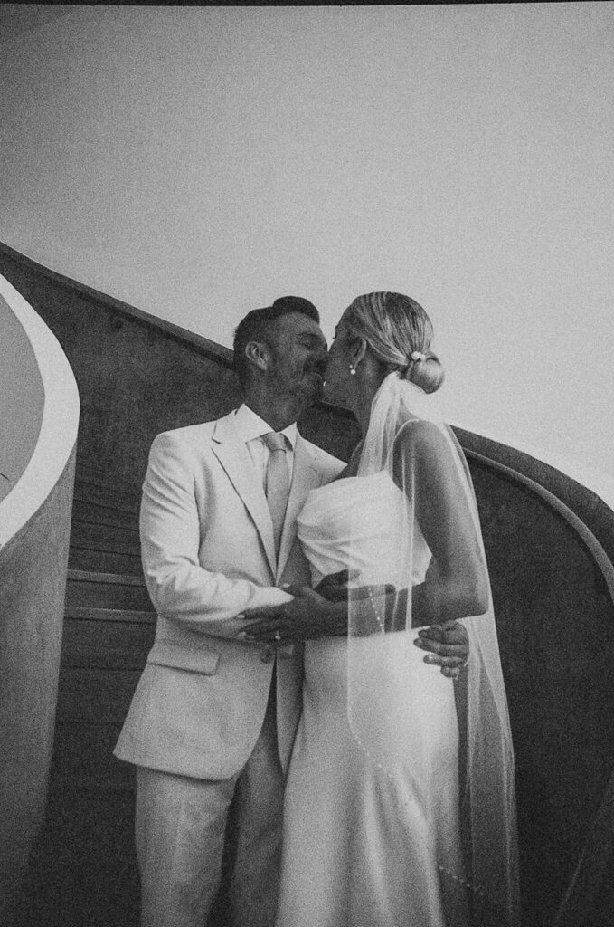 bride and groom kissing in curved staircase in Mexico
