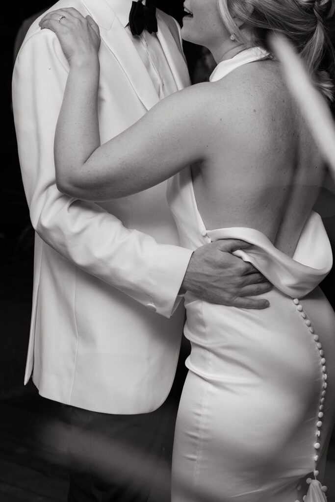 bride and groom in white tux and backless gown during first dance